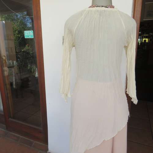 Pretty long permanent creased high-low cream top with long angel point sleeves size 32/8. As new.