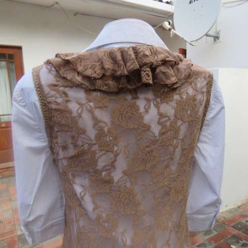 Stylish light brown acrylic stretch lace sleeveless gilet with wide frill all around. Size 34/10.
