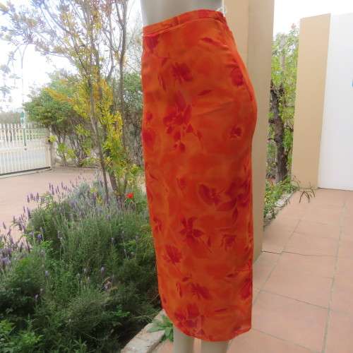 Eyecatching orange floral bodycon skirt in sheer viscose with lining. Size 32/8 by TOPICS.As new