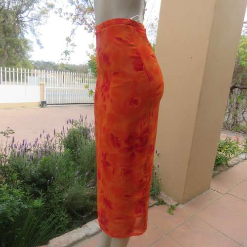 Eyecatching orange floral bodycon skirt in sheer viscose with lining. Size 32/8 by TOPICS.As new