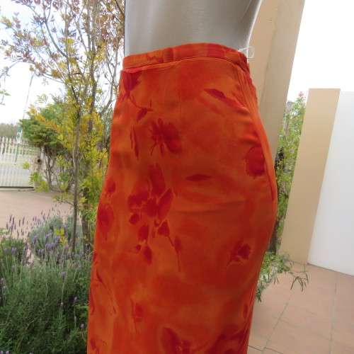 Eyecatching orange floral bodycon skirt in sheer viscose with lining. Size 32/8 by TOPICS.As new
