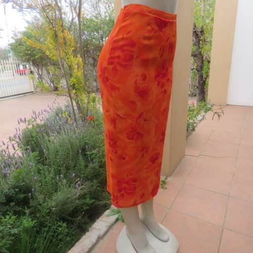 Eyecatching orange floral bodycon skirt in sheer viscose with lining. Size 32/8 by TOPICS.As new