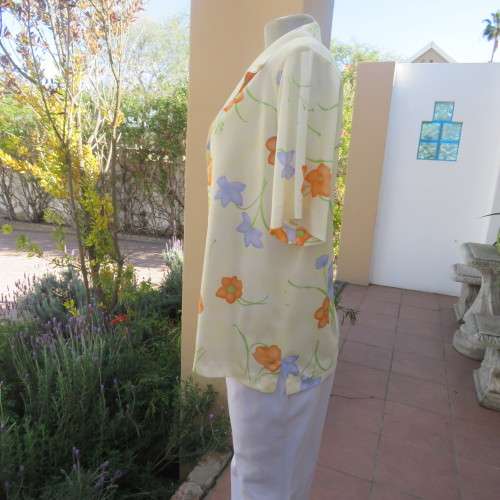 Tastefull patterned slip over top in pale yellow with orange and lilac flowers size 42/18.