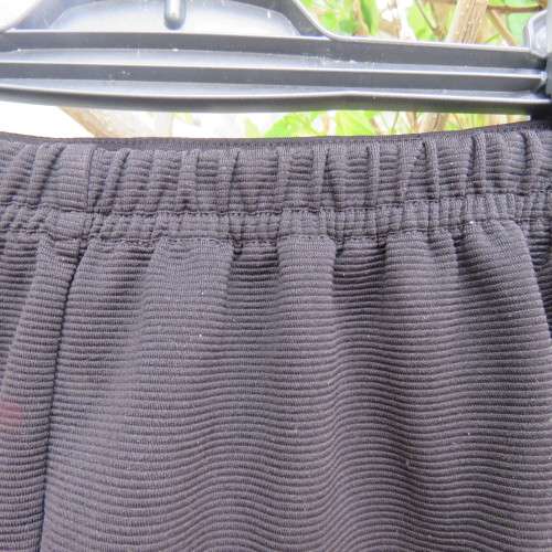Little black ribbed polyester skirt. For girl 12 to 13 years old. Buckle on front. As new.