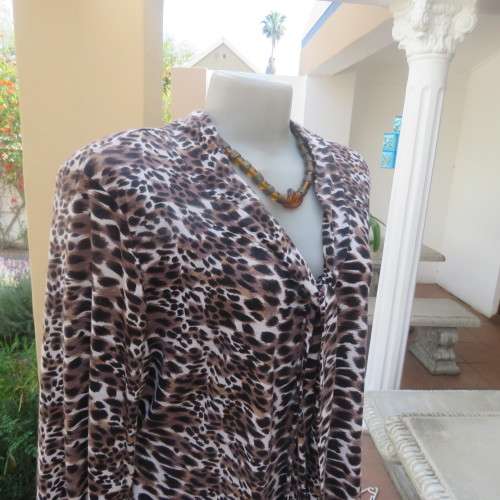 Soft and comfy polyester stretch top in animal print. Butt down with banded tie collar. Size 44/20