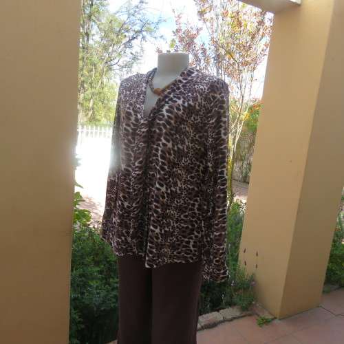 Soft and comfy polyester stretch top in animal print. Butt down with banded tie collar. Size 44/20