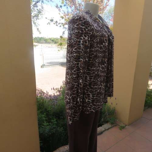 Soft and comfy polyester stretch top in animal print. Butt down with banded tie collar. Size 44/20