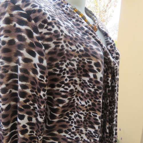 Soft and comfy polyester stretch top in animal print. Butt down with banded tie collar. Size 44/20