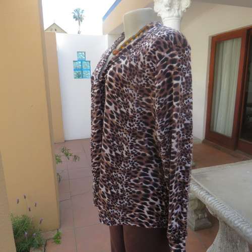 Soft and comfy polyester stretch top in animal print. Butt down with banded tie collar. Size 44/20