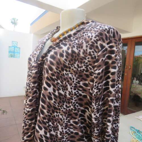 Soft and comfy polyester stretch top in animal print. Butt down with banded tie collar. Size 44/20
