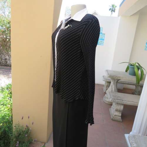 Elegant permanent pleated black top with thin diagonal stripes. Long sleeves. Size 38/14. As new.