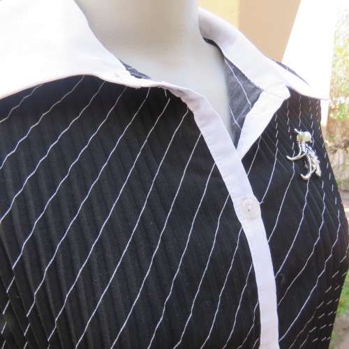 Elegant permanent pleated black top with thin diagonal stripes. Long sleeves. Size 38/14. As new.