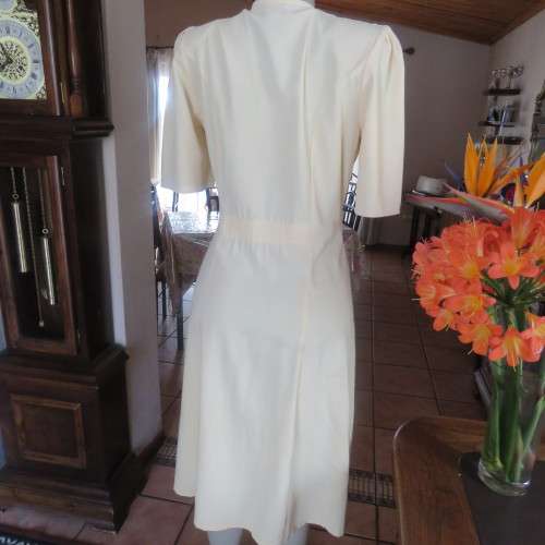 Fabulous corn colour dress with double breast fold over top. Pleated bottom. Size 36/12.Good cond.