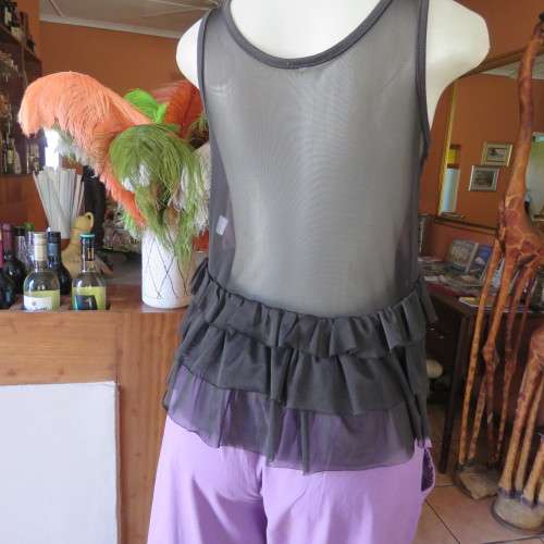 Cute little black netting top. Pale lilac underlay on front. Scooped neckline. Size 34/10. as new.