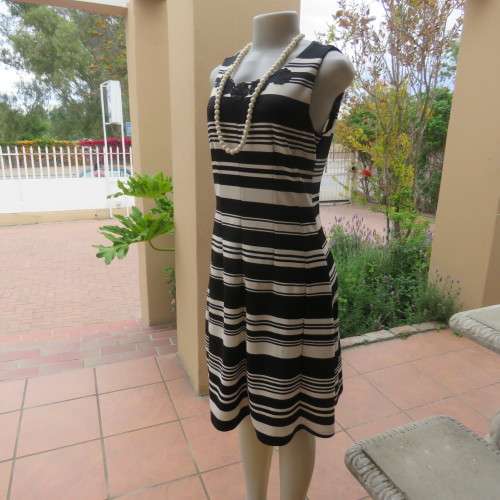 Beautiful black and cream sleeveless dress Size 34 as on doll Can fit size 36 Good condition
