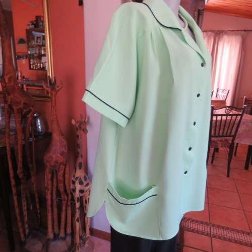 Lime green short sleeve top. Round collar. Size 46 to 48. By . Good condition.