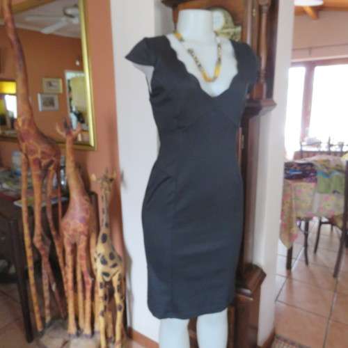 Fabulous sleek black dress with wide scalloped neckline. By `Massumi`. Size 34/10. Never used. New.