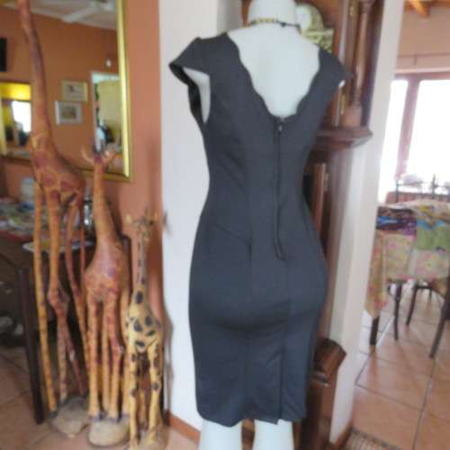 Fabulous sleek black dress with wide scalloped neckline. By `Massumi`. Size 34/10. Never used. New.
