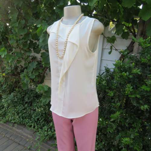 Unique cream sleeveless top with button down back. Size 34/10. By `Oakridge`. New condition.