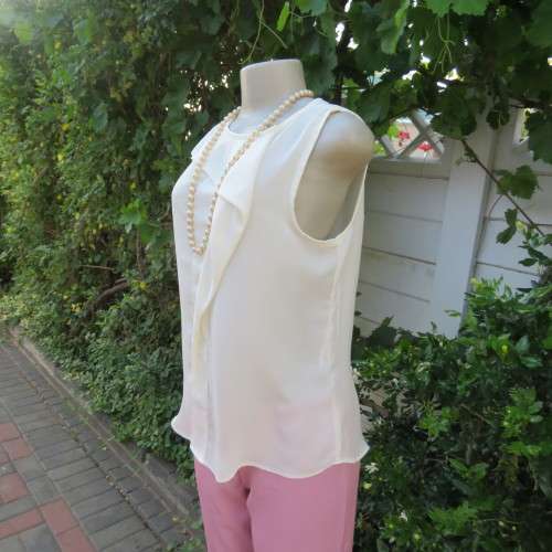 Unique cream sleeveless top with button down back. Size 34/10. By `Oakridge`. New condition.