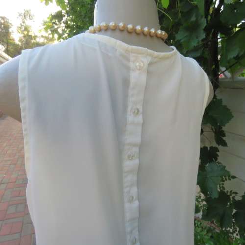 Unique cream sleeveless top with button down back. Size 34/10. By `Oakridge`. New condition.