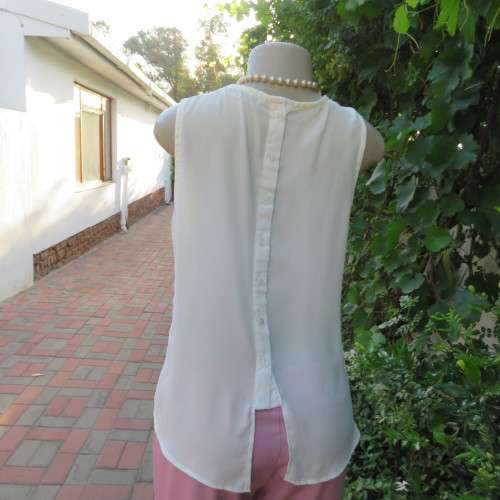 Unique cream sleeveless top with button down back. Size 34/10. By `Oakridge`. New condition.