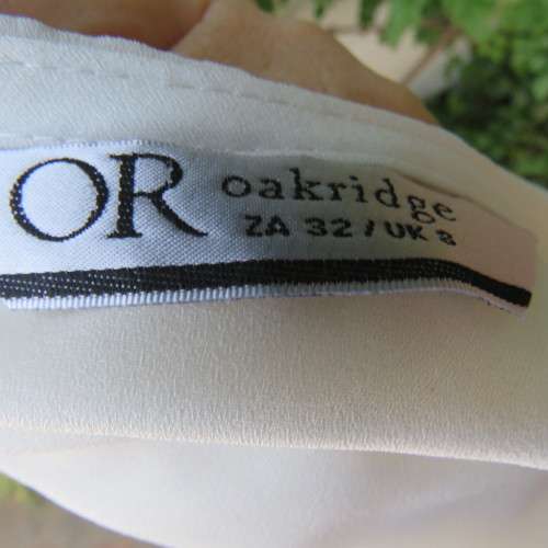 Unique cream sleeveless top with button down back. Size 34/10. By `Oakridge`. New condition.