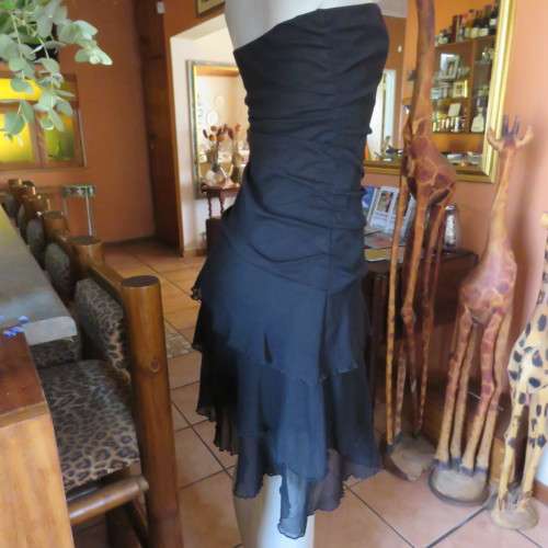 Little black dress with frilled bottom and ruched strapless top. Size 34/10 By `Jin Taiyang`. As new