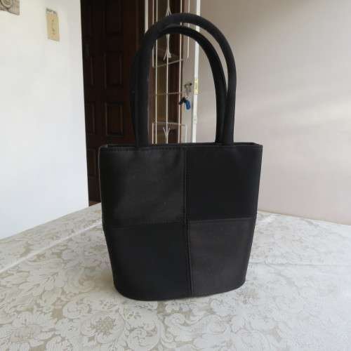 Small black bucket style handbag in shiny blocked vinyl .Size 18 x 16cm. As new