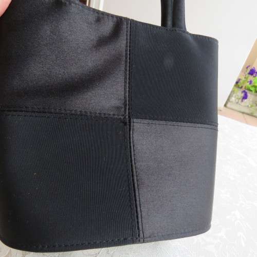 Small black bucket style handbag in shiny blocked vinyl .Size 18 x 16cm. As new