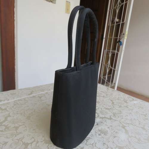 Small black bucket style handbag in shiny blocked vinyl .Size 18 x 16cm. As new