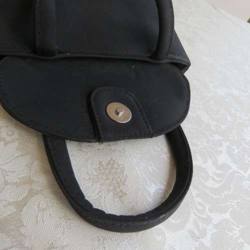 Small black bucket style handbag in shiny blocked vinyl .Size 18 x 16cm. As new