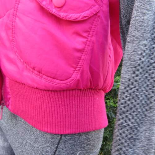 Warm magenta pink padded zip up waistcoat in size 36/12. Front pockets. Knitted ribbings.