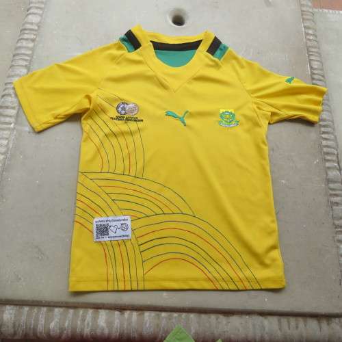 Boy`s Puma Football club yellow stretch polyester top with green/black stripe. Size 4 to 5 years.