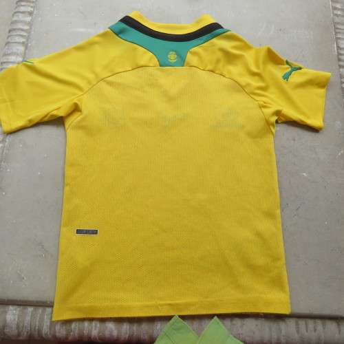 Boy`s Puma Football club yellow stretch polyester top with green/black stripe. Size 4 to 5 years.