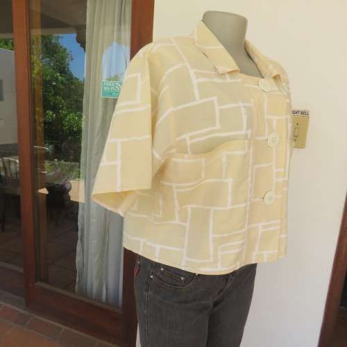 Unique cropped short sleeve `GIGGLES` top in vanilla and white blocks. Size 42/18 by `DAVID CLINE`.