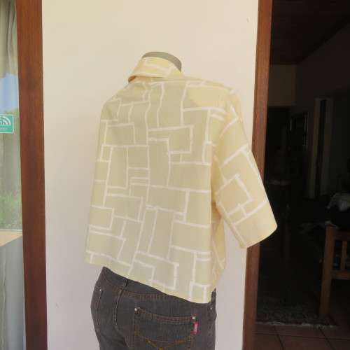 Unique cropped short sleeve `GIGGLES` top in vanilla and white blocks. Size 42/18 by `DAVID CLINE`.