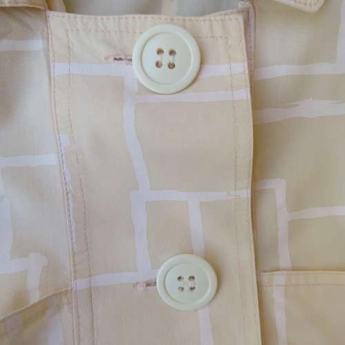 Unique cropped short sleeve `GIGGLES` top in vanilla and white blocks. Size 42/18 by `DAVID CLINE`.