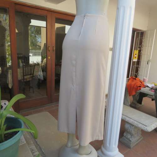 Elegant beige ankle length pencil skirt. Bandless with zip and pleat at back. Size 32/8.Good cond.