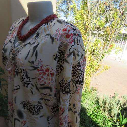 Pretty slip over silky polyester rich cream top with red and black unique designs.Size 44/20.As new