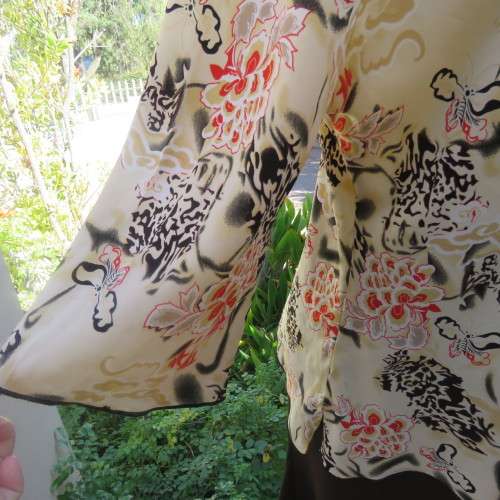 Pretty slip over silky polyester rich cream top with red and black unique designs.Size 44/20.As new