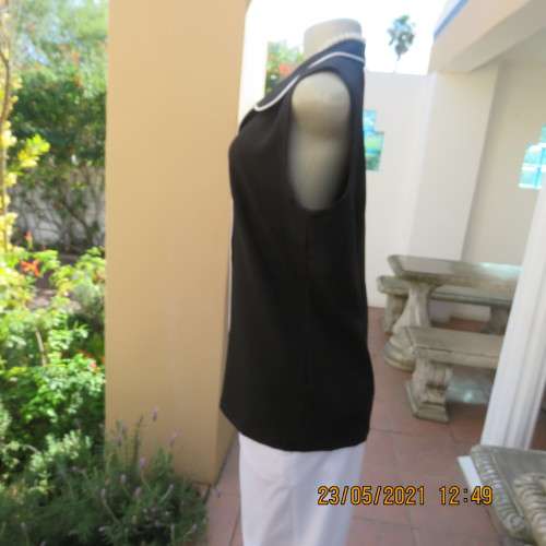 In style black sleeveless top with white trimmings.Button down with open collar By NEW ERA size 36