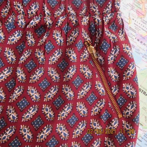 As new loose printed pants with tapered legs in maroon with navy/white pattern.Size 48/24 by DONNA C
