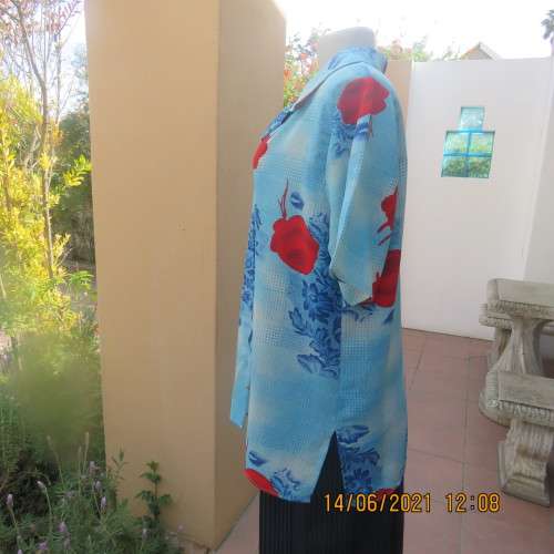 As new cheerful short sleeve top in blue floral pattern and red roses. Button down.Size 40/16.