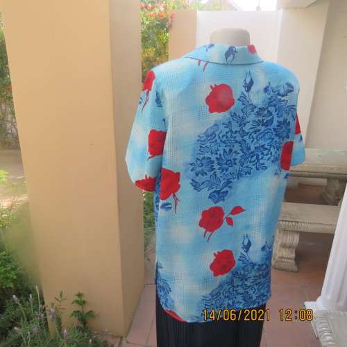 As new cheerful short sleeve top in blue floral pattern and red roses. Button down.Size 40/16.