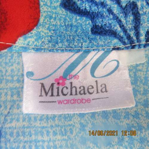 As new cheerful short sleeve top in blue floral pattern and red roses. Button down.Size 40/16.