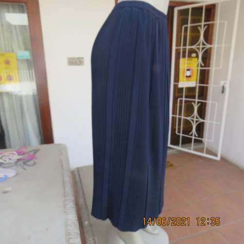 Smart permanent pleated navy 100% polyester calf length skirt with elasticated waist.Size 36/12.