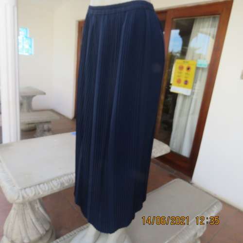 Smart permanent pleated navy 100% polyester calf length skirt with elasticated waist.Size 36/12.