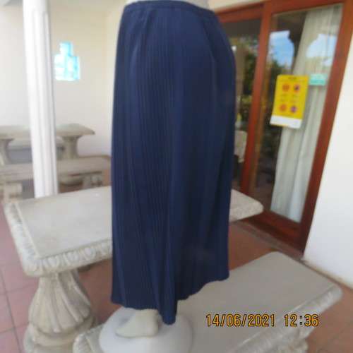 Smart permanent pleated navy 100% polyester calf length skirt with elasticated waist.Size 36/12.