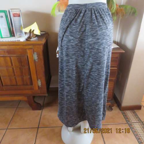 Maxi skirt in black with broken white horizontal lines. Some gathering and 2 side pockets. Size 32/8